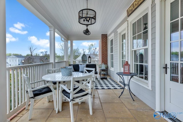 balcony featuring a porch, outdoor dining area, and a sunroom