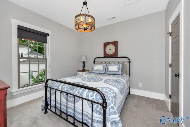 carpeted bedroom featuring an inviting chandelier, baseboards, and visible vents