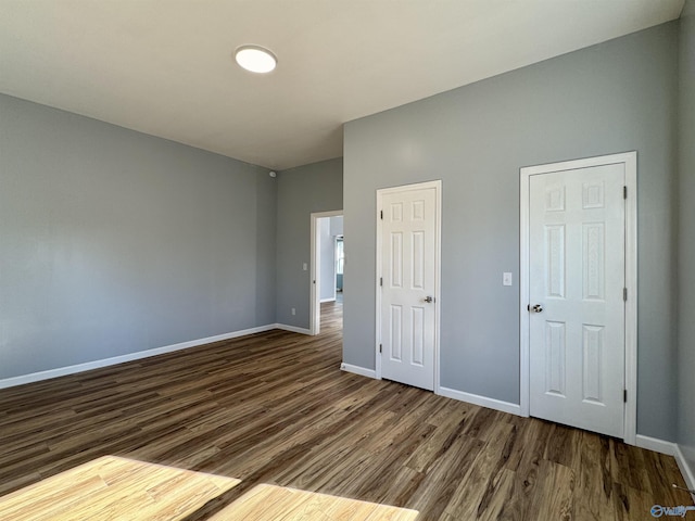 unfurnished bedroom with dark wood-type flooring