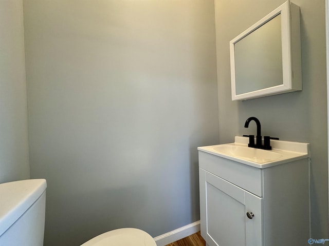 bathroom featuring hardwood / wood-style floors, vanity, and toilet