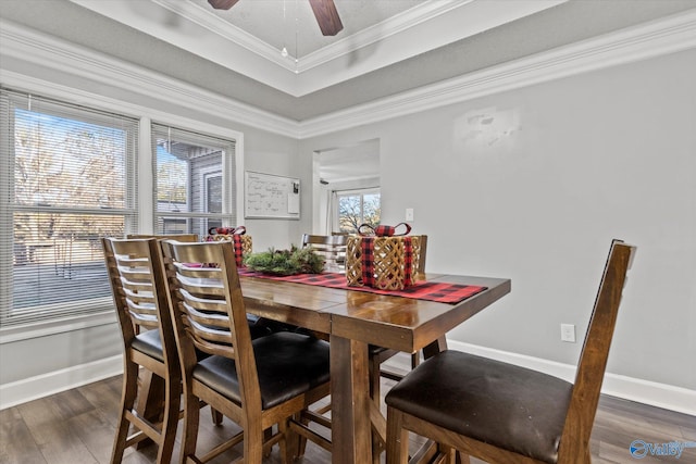 dining room featuring a tray ceiling, crown molding, ceiling fan, and dark hardwood / wood-style floors