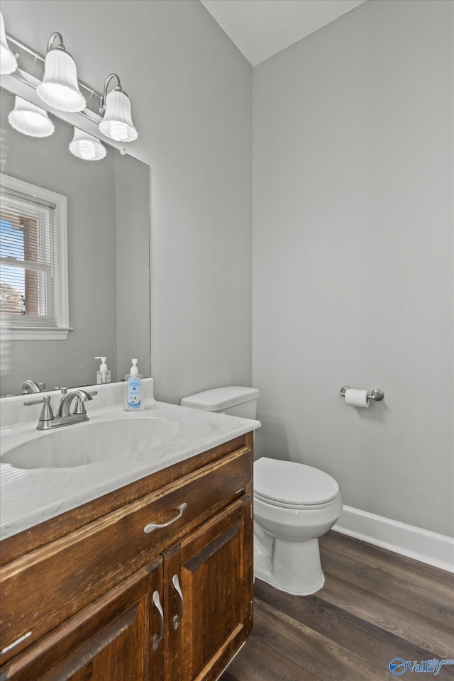 bathroom with hardwood / wood-style flooring, vanity, and toilet