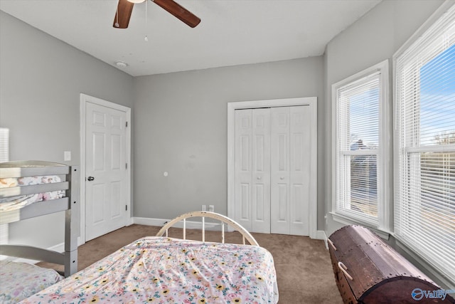 bedroom with a closet, dark carpet, and ceiling fan