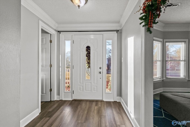 entrance foyer with a textured ceiling, dark hardwood / wood-style floors, and ornamental molding