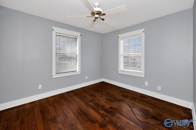 empty room with a ceiling fan, visible vents, baseboards, and wood finished floors