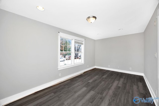 unfurnished room featuring dark wood finished floors and baseboards