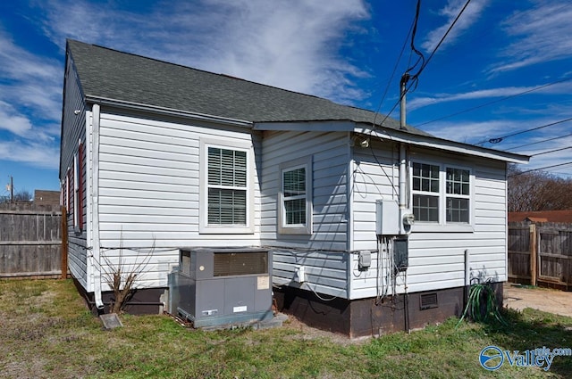 back of house with roof with shingles, a yard, central AC unit, crawl space, and fence