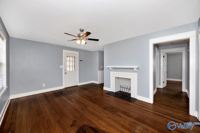 unfurnished living room with ceiling fan, a fireplace, baseboards, and wood finished floors