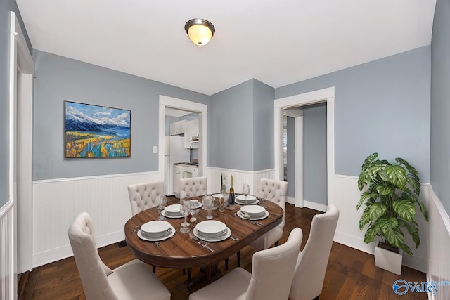 dining room with wainscoting and wood finished floors