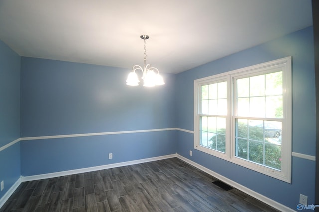 unfurnished room featuring dark hardwood / wood-style floors and a chandelier