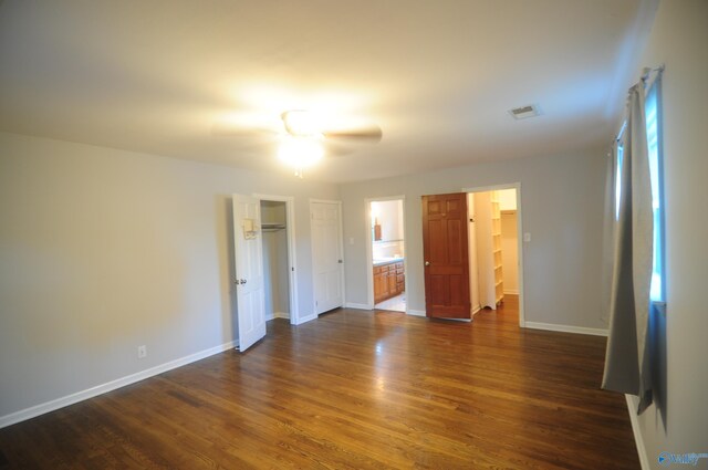 unfurnished bedroom featuring ensuite bath, dark hardwood / wood-style floors, and ceiling fan