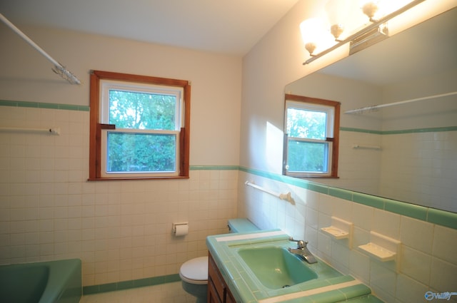 full bathroom featuring plenty of natural light, vanity, toilet, and tiled shower / bath