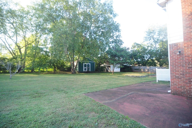 view of yard featuring a storage unit and a patio