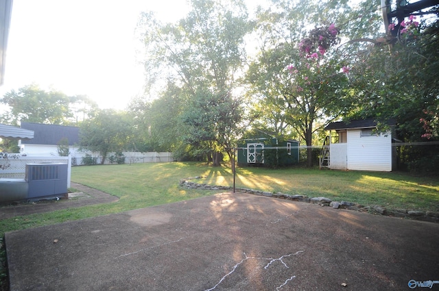 view of yard featuring cooling unit, a shed, and a patio