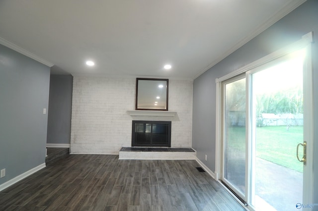 unfurnished living room featuring brick wall, a fireplace, dark hardwood / wood-style floors, and ornamental molding