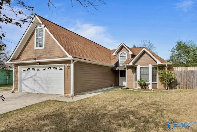 view of front facade with a front yard, roof with shingles, driveway, and fence
