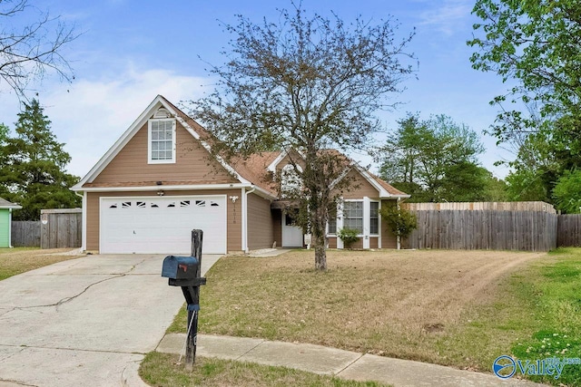 traditional-style house with a front lawn, fence, a garage, and concrete driveway