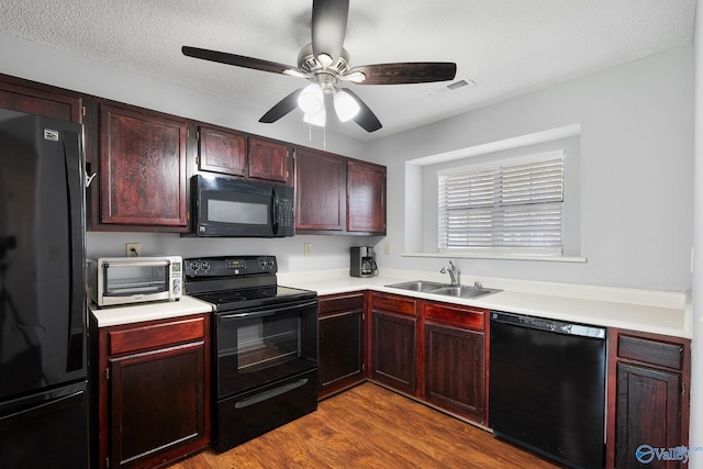 kitchen featuring black appliances, wood-type flooring, ceiling fan, sink, and a textured ceiling