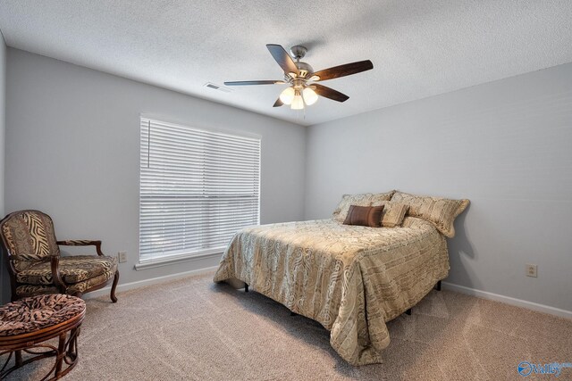 bedroom with a textured ceiling, ceiling fan, and carpet flooring