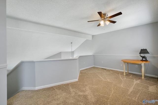 additional living space featuring carpet flooring, a textured ceiling, vaulted ceiling, and ceiling fan