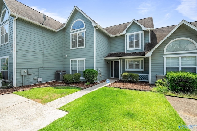 view of front property featuring central AC unit and a front yard