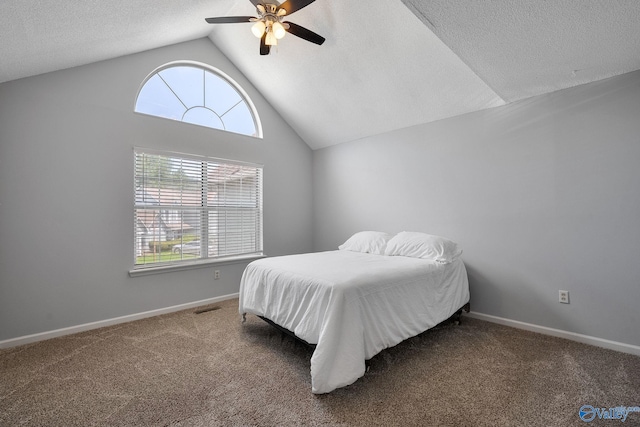 carpeted bedroom with a textured ceiling, vaulted ceiling, and ceiling fan