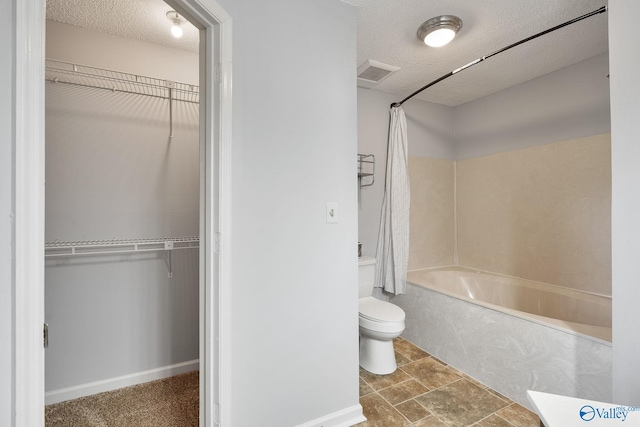 bathroom featuring toilet, a textured ceiling, tile patterned flooring, and shower / bath combination with curtain