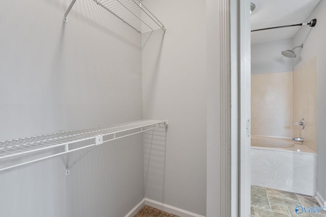 walk in closet with stone finish flooring