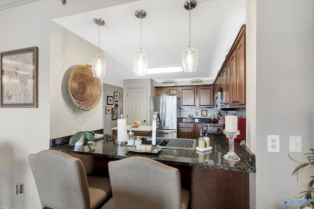 12100 Two Rivers Dr Phi, Phi, Athens, AL 35611 - kitchen featuring appliances with stainless steel finishes, a peninsula, pendant lighting, dark stone counters, and a breakfast bar