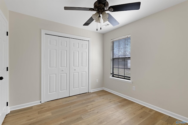 unfurnished bedroom featuring ceiling fan, light hardwood / wood-style floors, and a closet