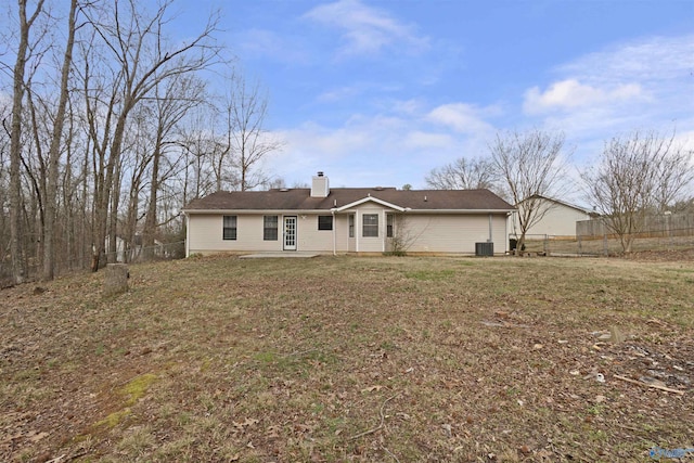 rear view of property featuring central AC unit and a yard