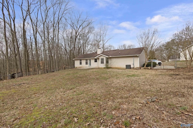 exterior space with central AC and a front lawn