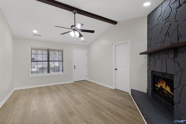 unfurnished living room with ceiling fan, light hardwood / wood-style flooring, a large fireplace, and lofted ceiling with beams