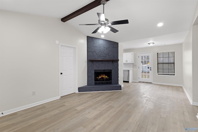 unfurnished living room featuring ceiling fan, lofted ceiling with beams, a large fireplace, and light wood-type flooring