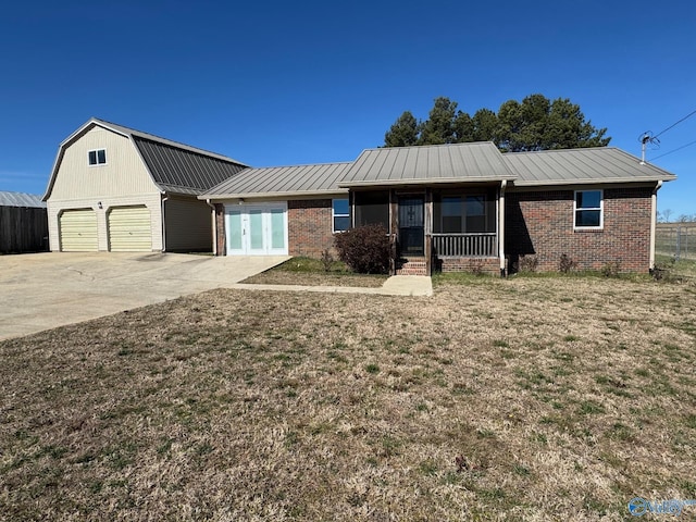 ranch-style house with metal roof, brick siding, a gambrel roof, concrete driveway, and a front lawn