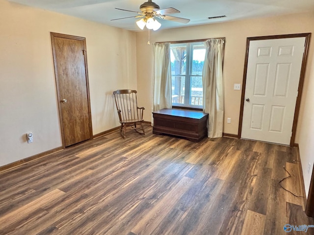 sitting room with wood finished floors, visible vents, and baseboards