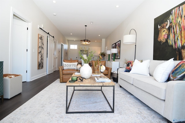 living area featuring a barn door, recessed lighting, wood finished floors, and baseboards