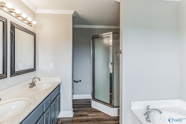 bathroom with crown molding, a textured ceiling, shower with separate bathtub, hardwood / wood-style flooring, and double sink vanity