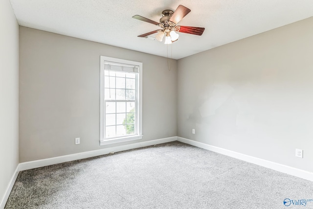 carpeted empty room featuring a ceiling fan, a textured ceiling, and baseboards