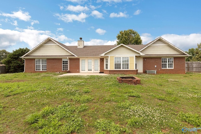 rear view of house featuring french doors, a lawn, a chimney, and brick siding