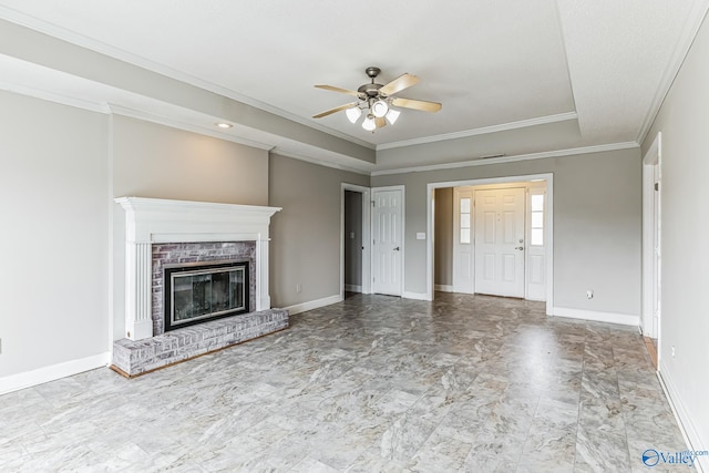 unfurnished living room with a fireplace, ceiling fan, a raised ceiling, and tile patterned floors