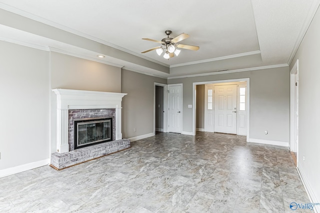 unfurnished living room with a ceiling fan, a brick fireplace, ornamental molding, and baseboards