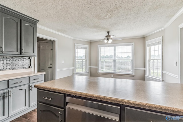 kitchen featuring dark wood-type flooring, a textured ceiling, crown molding, and ceiling fan