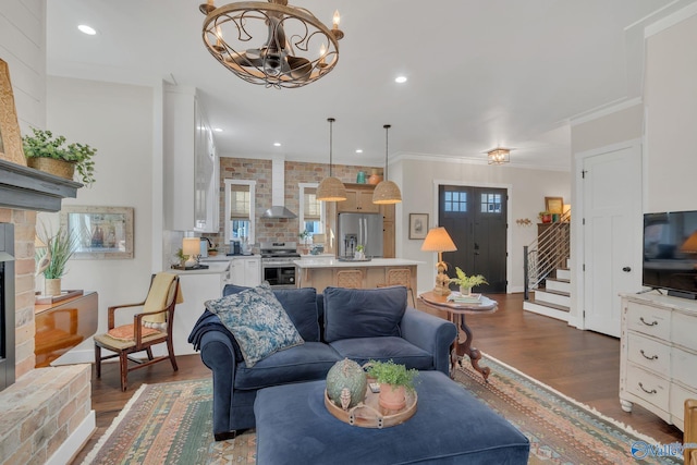 living room featuring sink, a notable chandelier, dark wood-type flooring, and ornamental molding