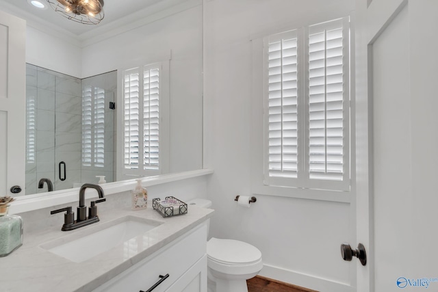 bathroom with vanity, a shower with door, ornamental molding, and toilet