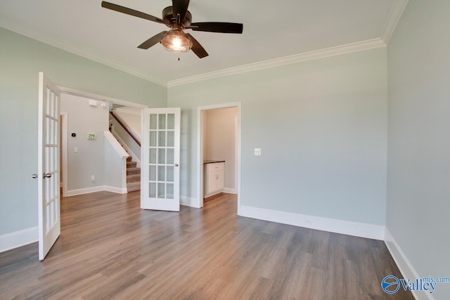 empty room with hardwood / wood-style flooring, ceiling fan, crown molding, and french doors