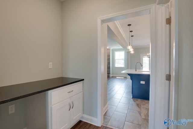 hall featuring ornamental molding and sink