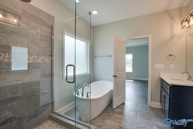 bathroom with vanity, hardwood / wood-style flooring, and separate shower and tub