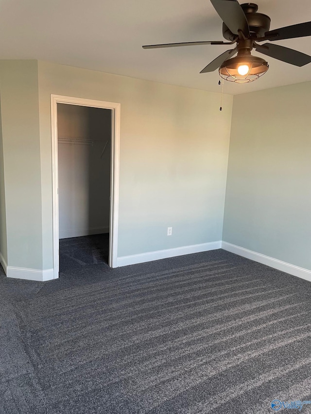 unfurnished room featuring ceiling fan and dark carpet