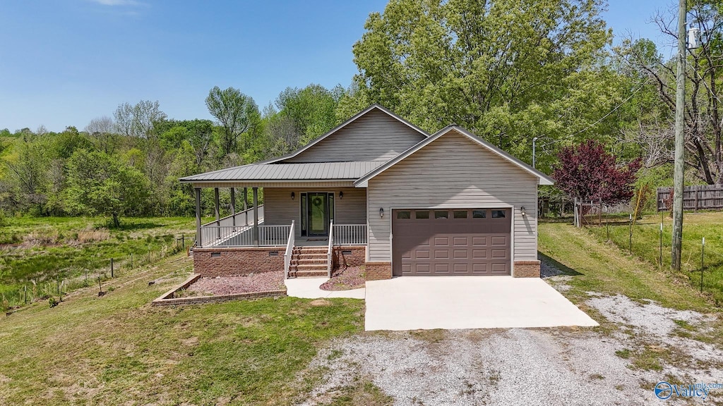 single story home with covered porch, fence, driveway, a front lawn, and an attached garage